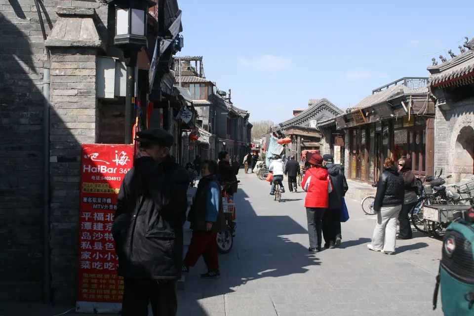 Shops, bicycles and pedestrians along a traditional Beijing hutong street